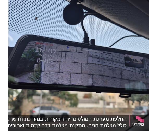 מראה אחורית עם מצלמה ברכב, מציגה תמונה של חניה